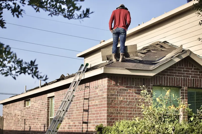 Professional roofer working on a residential roof in Clay Ridge